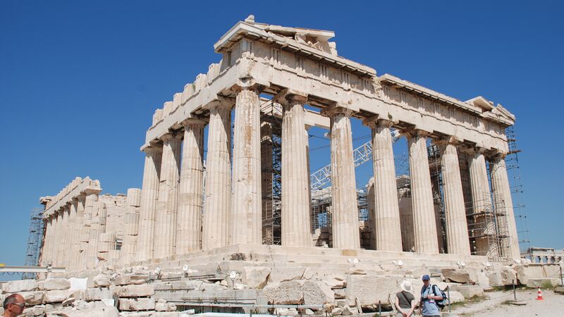 The majestic structure of the Acropolis in Athens against a brilliant blue sky.