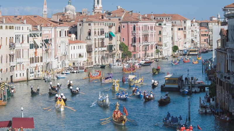 Boats cruising down a canal at the Regatta in Venice