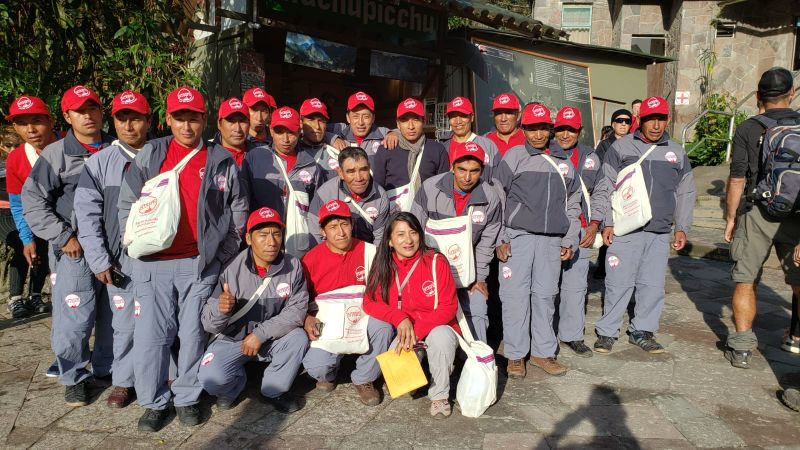 A group of porters wearing red caps on a trail in Peru