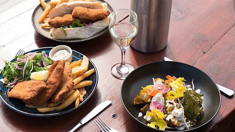 A collection of meals on a wooden table from Pennicott restuarant in Bruny Island.
