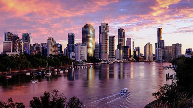 Brisbane's city skyline from a river vantage point at sunset. 