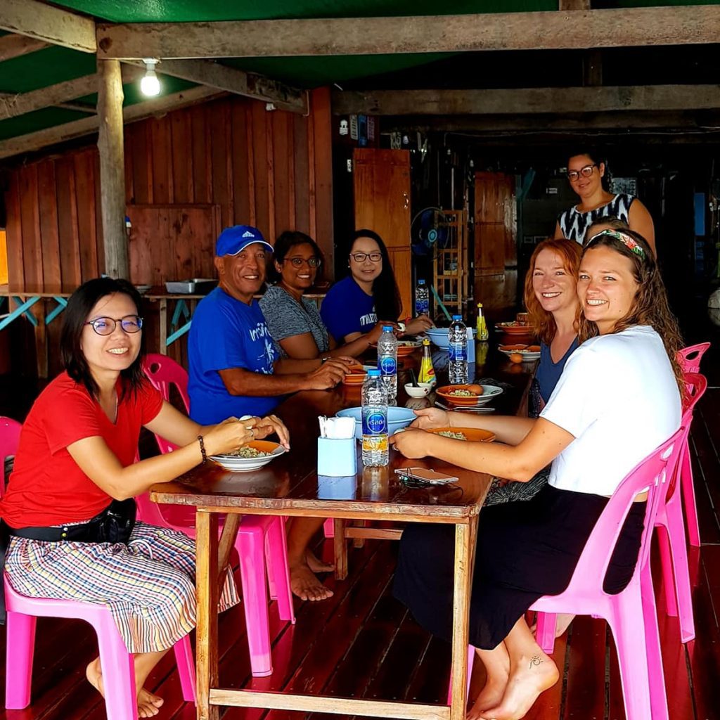 A group of happy travellers enjoying a meal in Thailand