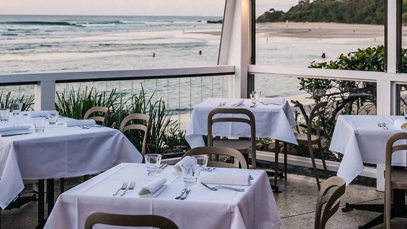 Outdoor seating by the water at Beach Byron Bay. 