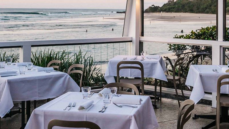 Outdoor seating by the water at Beach Byron Bay.
