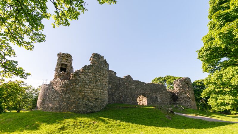 The crumbling ruins of Inverlochy Castle in Glen Coe on a clear, sunny day in Scotland.