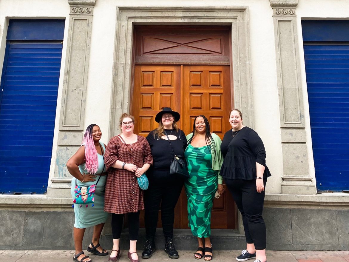 Five women standing in front of a blue building in Mexico