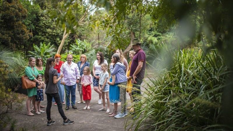 A group of travellers on a tour with an Indigenous guide in the gardens
