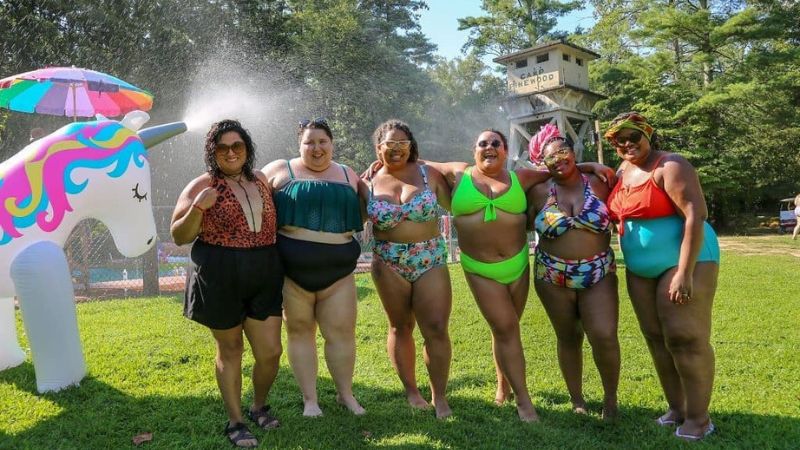 Six smiling woman in swimsuits at a waterpark
