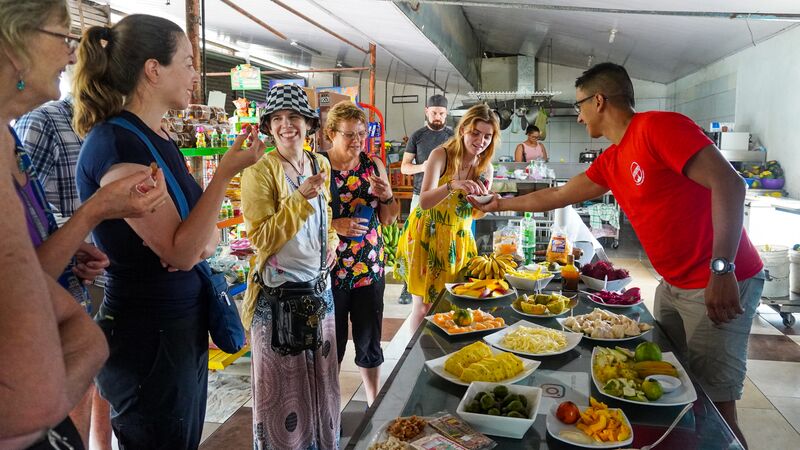 A group of people surrounding a table laden with traditional Costa Rican food.