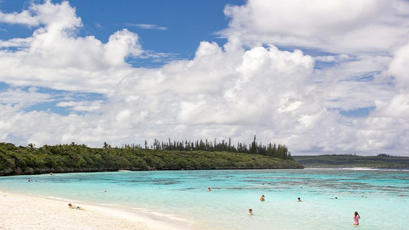 People enjoying the warm water of Yejele Beach in New Caledonia.