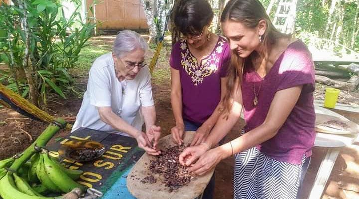 Three women collect roasted cacao beans in Costa Rica