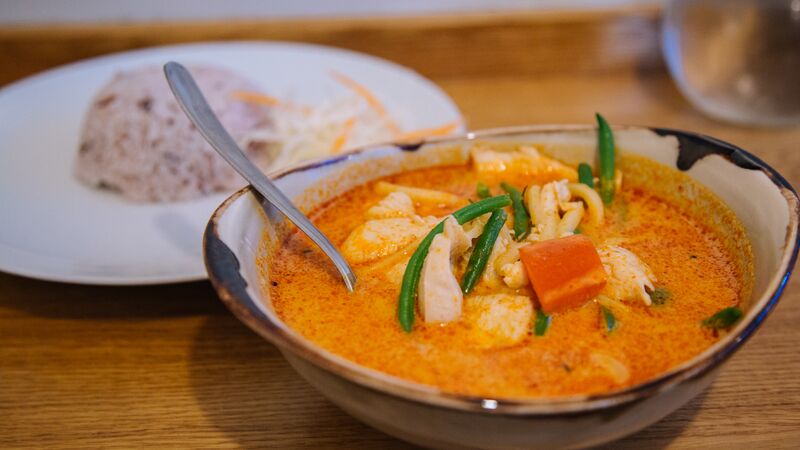 A bowl of fish curry accompanied with rice