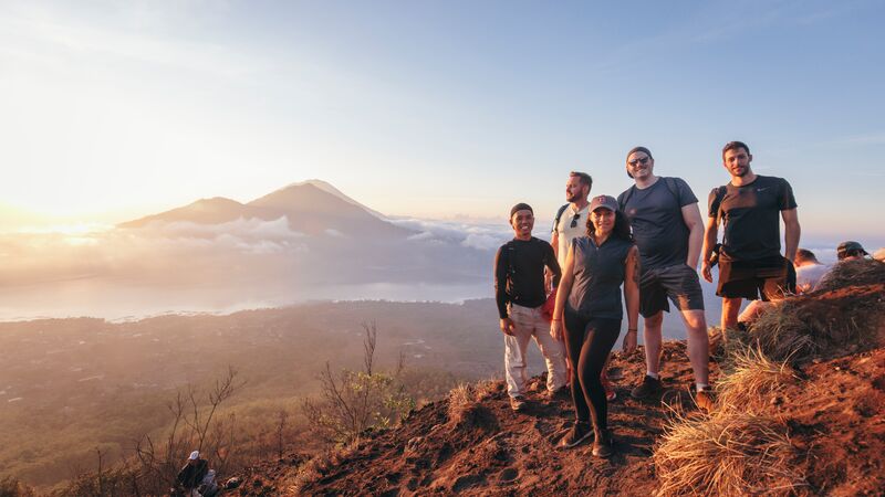 Five travellers standing at the summit of the Mt Batur sunrise hike in Bali