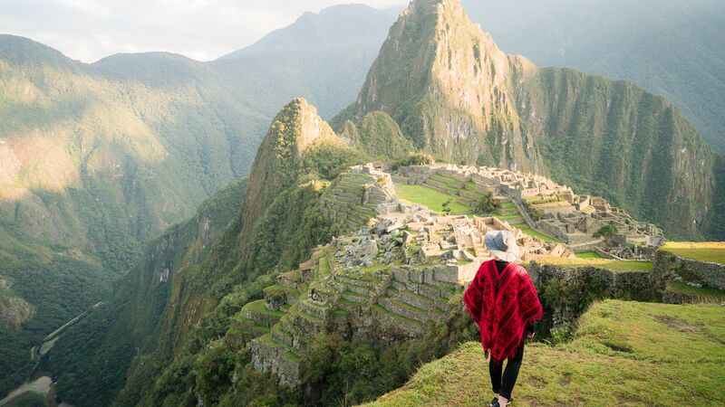 A lone traveller overlooking the ancient ruins of Machu Picchu. 