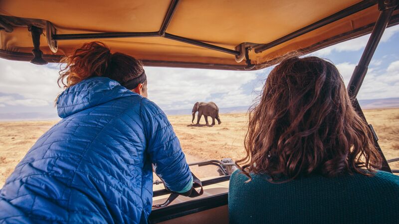 Two women spot an elephant in the distance on safari in Tanzania