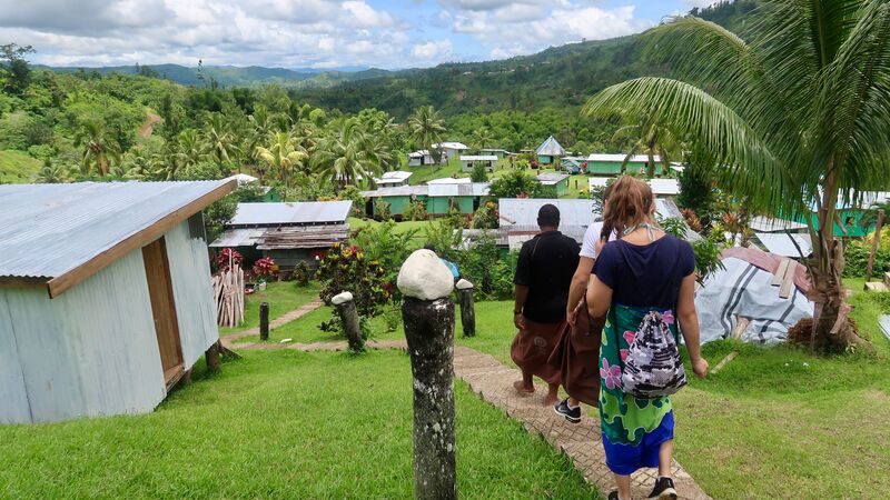 Travellers wearing a sulu following a local through the Nabalesere Village, Fiji