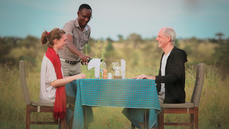 A pair of travellers sitting down to enjoy a traditional Tanzanian meal.