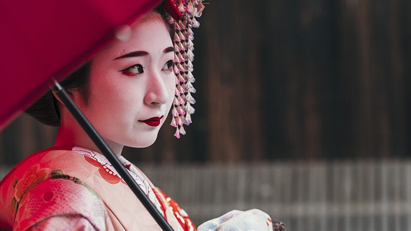 A traditional geisha looking off in the distance in Japan