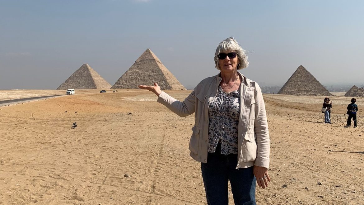 Intrepid traveller Caroline playing with perspective, pretending to hold up a pyramid in Egypt
