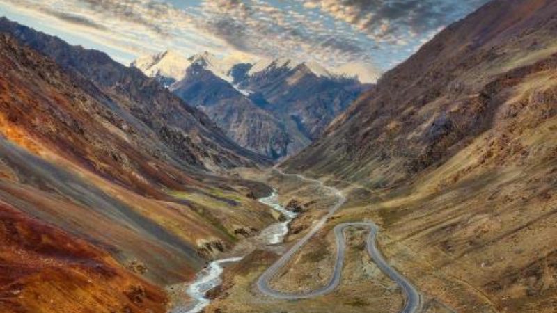 A winding highway alongside a river and nestled in between the Karakoram mountains in Pakistan. 