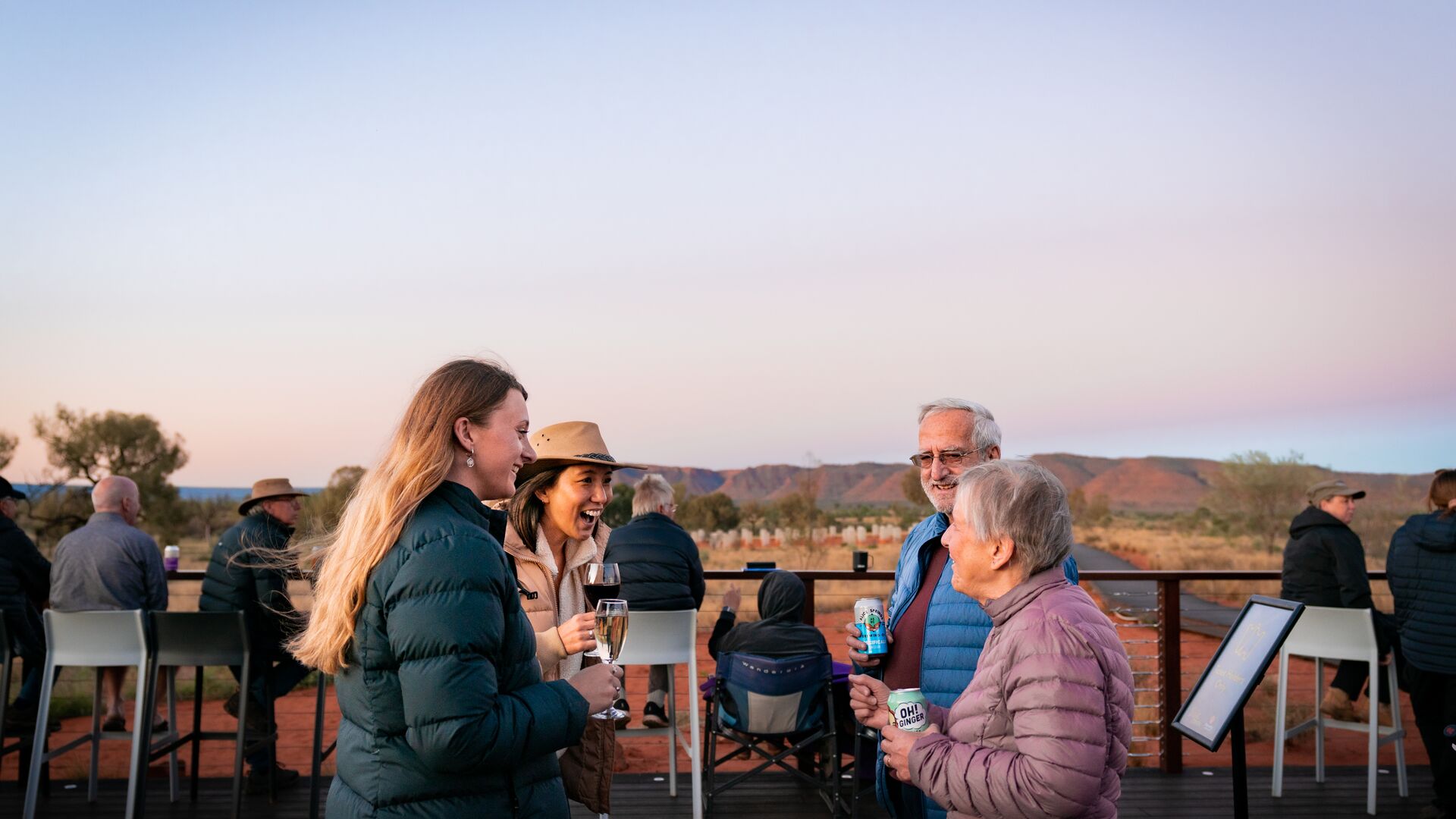 Four travellers enjoying a sunset drink at Kings Canyon Resort in the Northern Territory