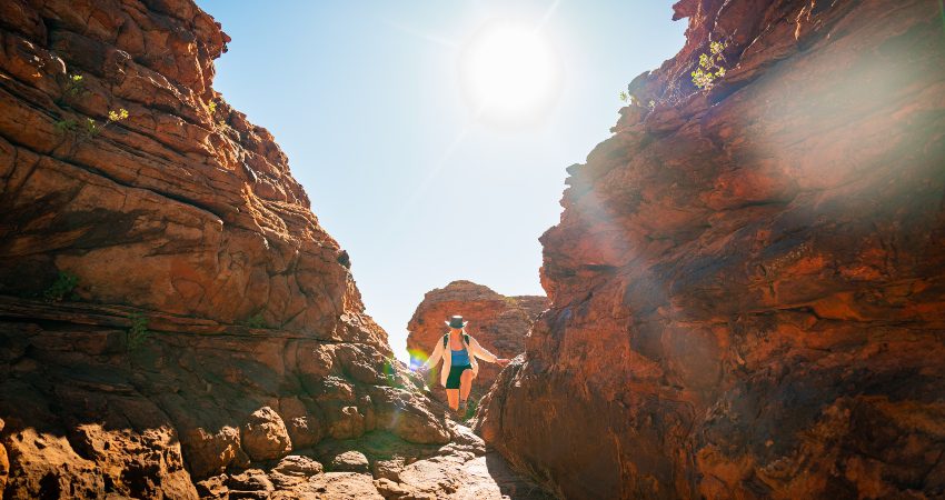 A traveller climbing through Priscilla's Crack on the Kings Canyon Rim Walk
