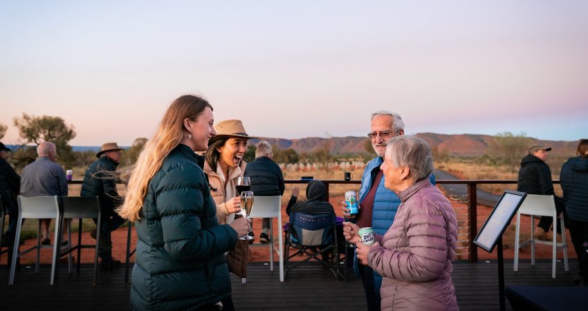 Four travellers enjoying a sunset drink at Kings Canyon Resort in the Northern Territory