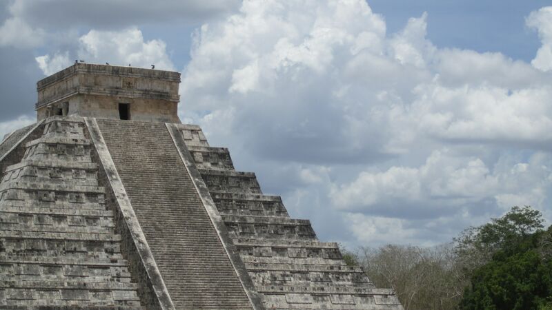 The imposing structure of Chichen Itza under a cloudy sky in Mexico. 