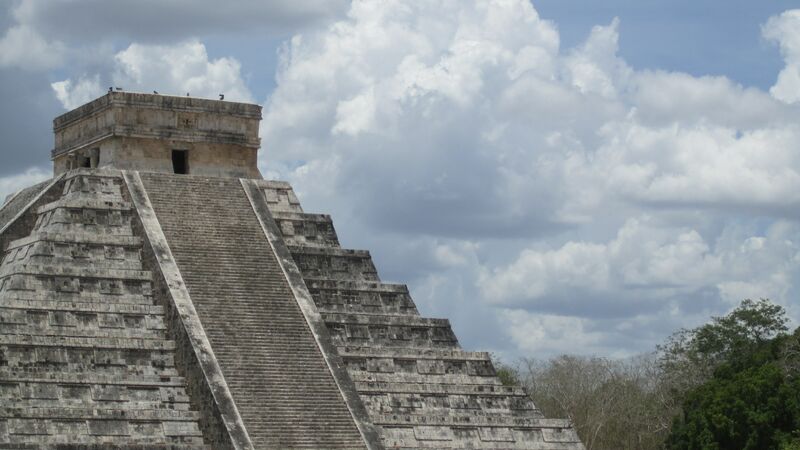 The imposing structure of Chichen Itza under a cloudy sky in Mexico.