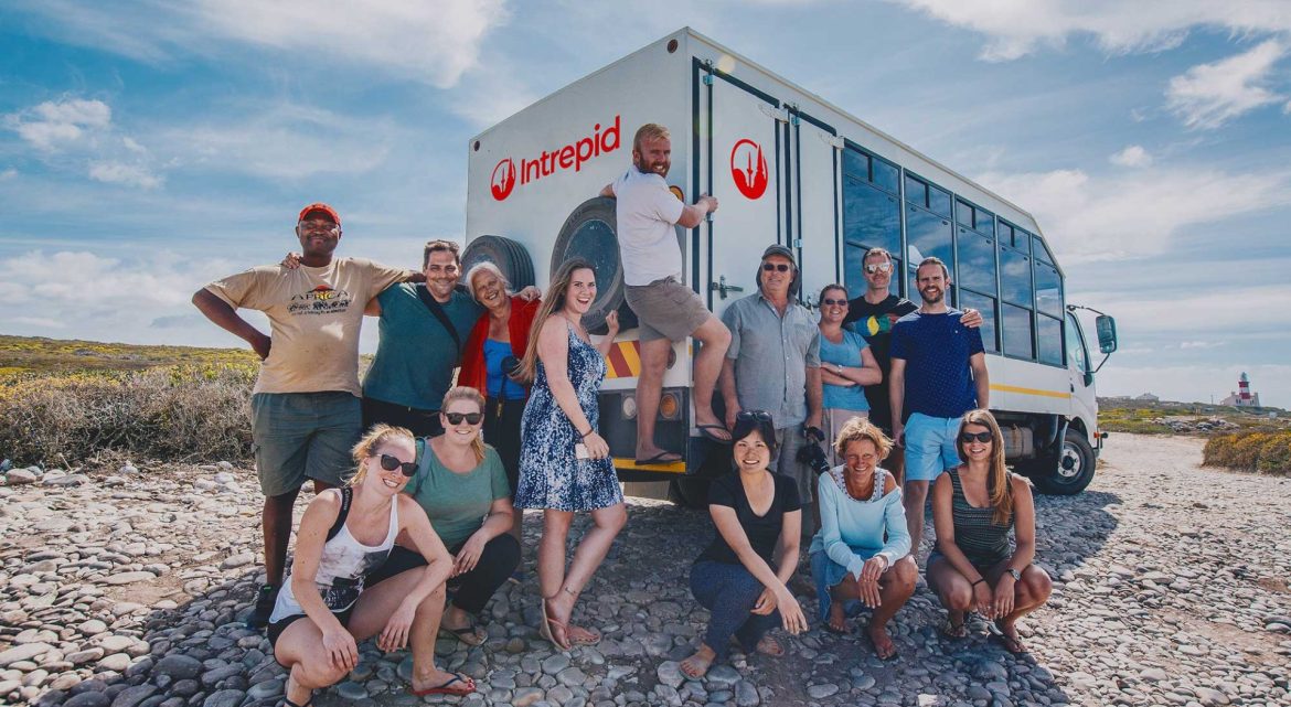A group of Intrepid travellers next to an overland truck.