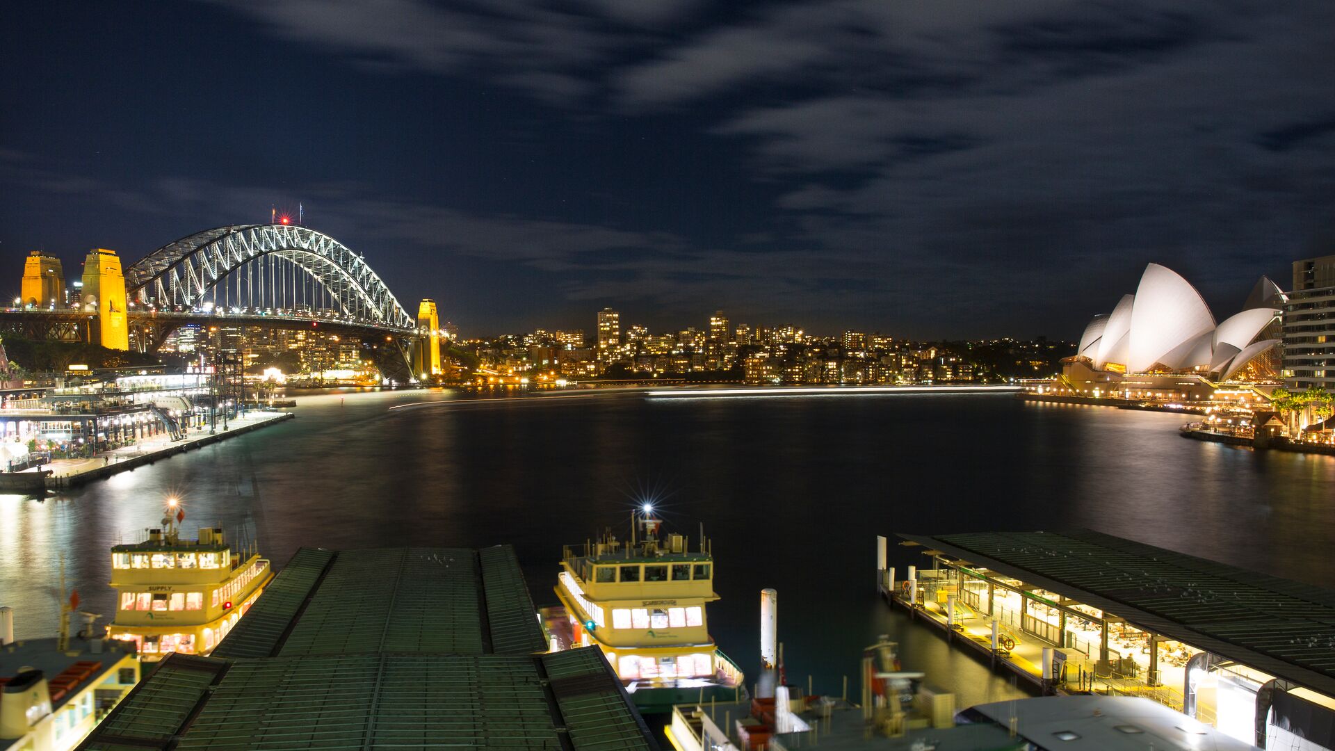 The Sydney Harbour at night with Bridge and Opera House lit up.