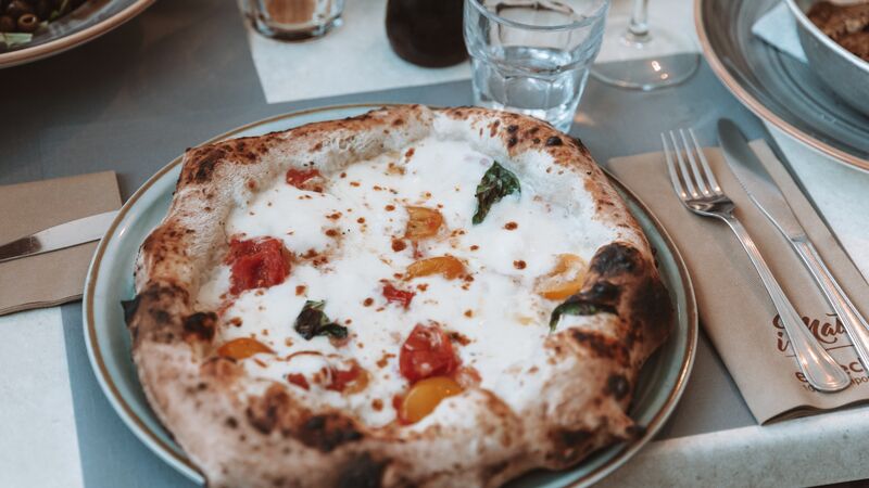A perfectly cooked pizza with tomatoes and Mozzarella.