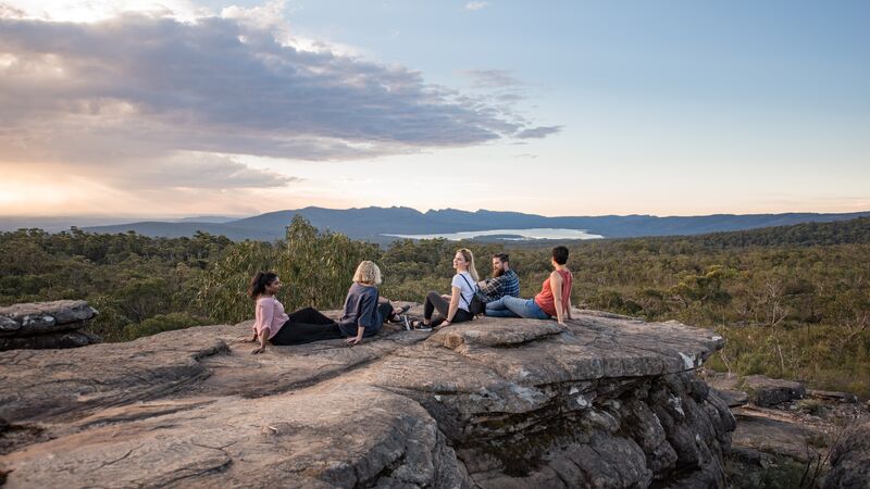 Five hikers resting on a rocky platform in the Grampians