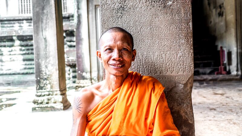 A monk sat down smiling in Angkor Wat, Cambodia