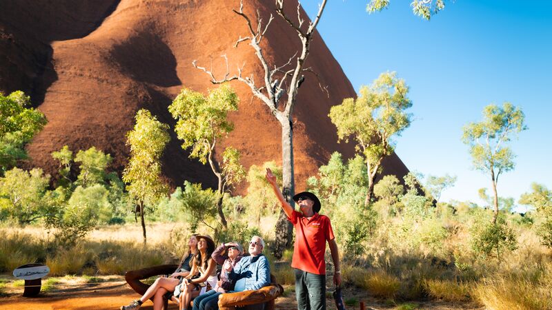 An Intrepid leader pointing out marks on Uluru's surface during a base walk. 