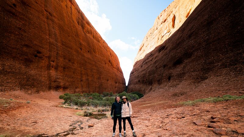 Two female travellers smiling for a photo in Walpa Gorge, Kata Tjuta.