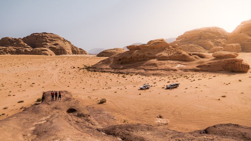 Th expansive landscape of the Wadi Rum Desert under a blazing summer sun.