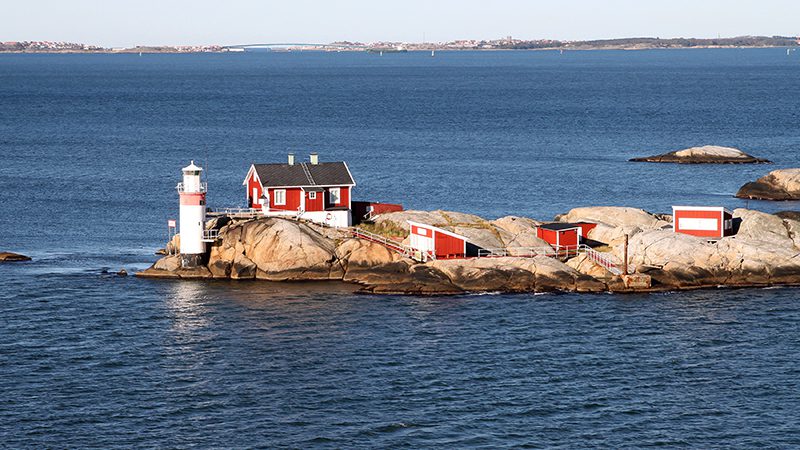 Lighthouse and red buildings on small rocky island in the archipelago on the North Sea at Gothenburg, Sweden in Scandinavia