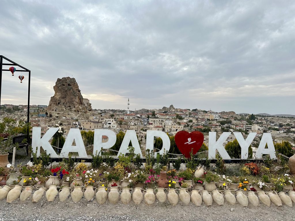 A sign reading 'Kapadokya' by one of the rock castles in Goreme.