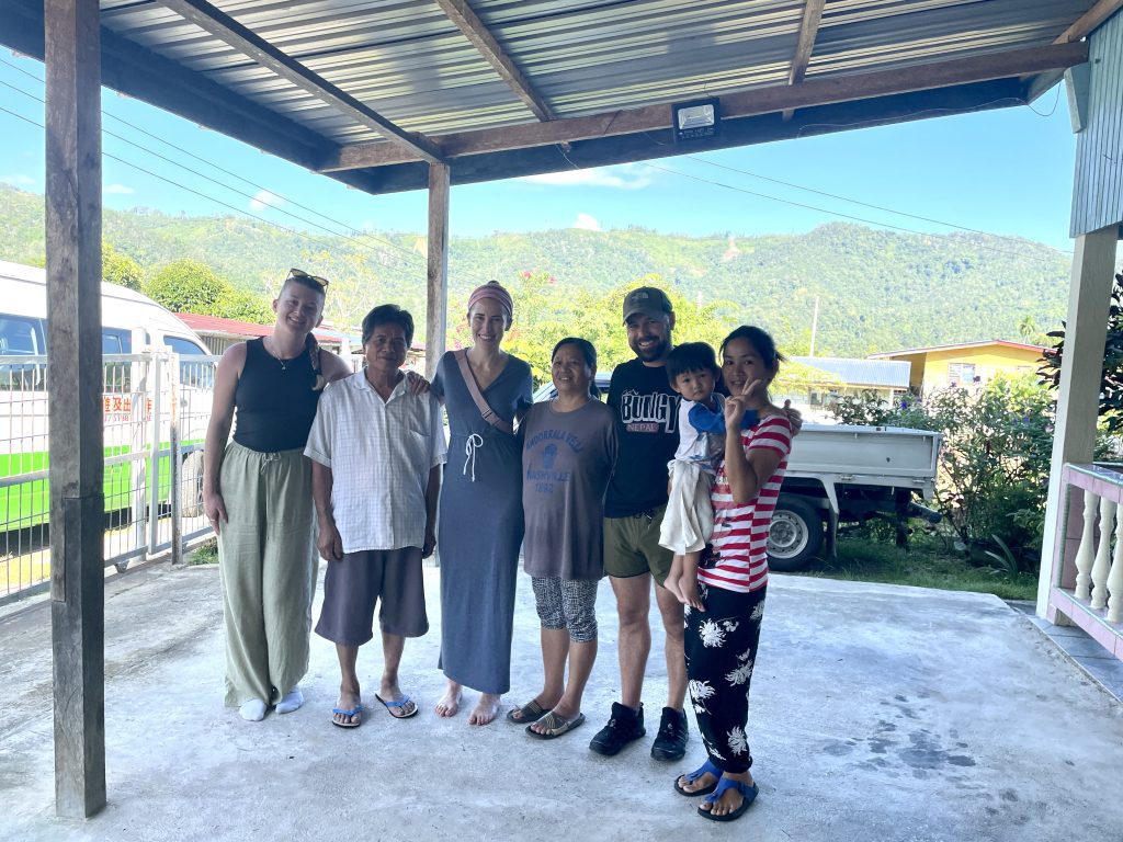 A group of travellers with a local family at a Dusun homestay in Sabah