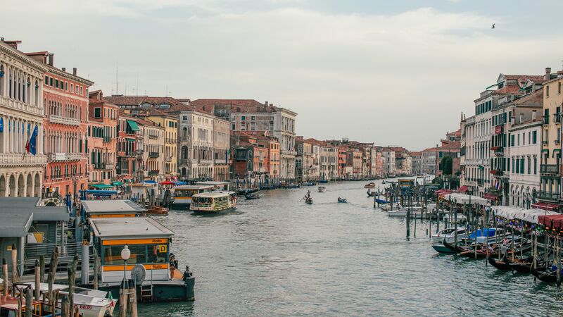 The bustling waters of a canal in Venice flanked with colourful buildings on either side.
