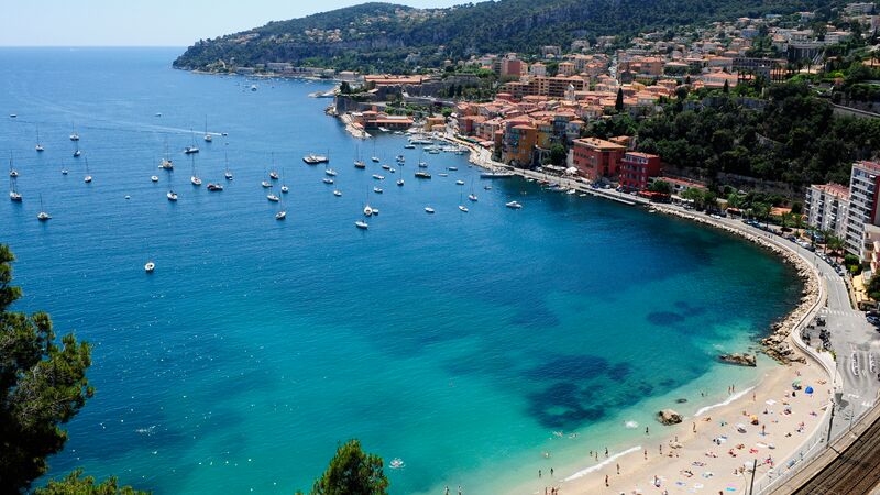 The sparkling turquoise waters of Nice with boats floating out to sea. 