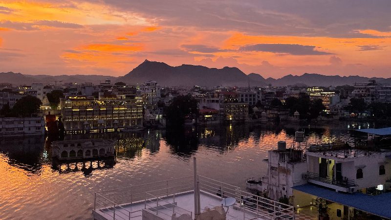 A beautiul sunset over the water of Lake Pichola and the rooftops of Udaipur. 