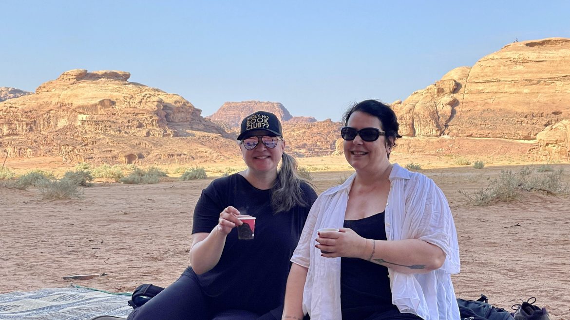 two women sitting together sipping tea