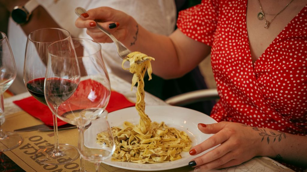 A traveller eating a bowl of truffle tagliatelle in Italy