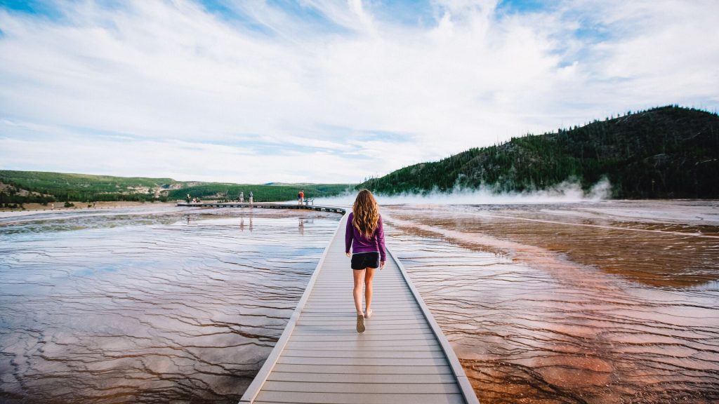 A traveller on a boardwalk trail to Old Faithful in Yellowstone National Park