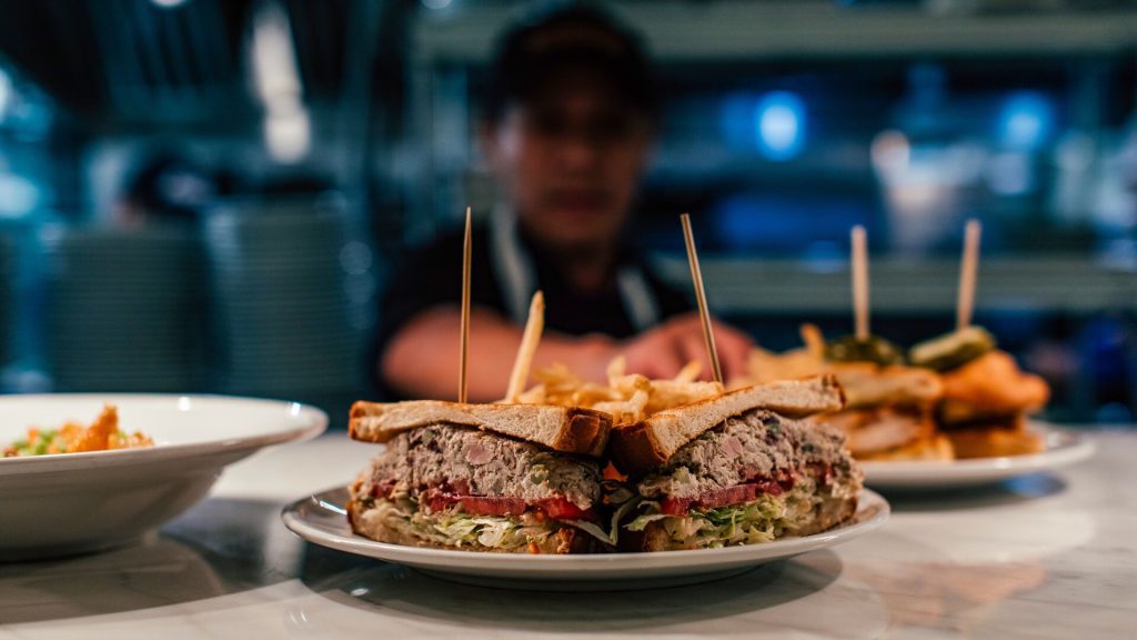 A chef sending a sandwich order out of the kitchen