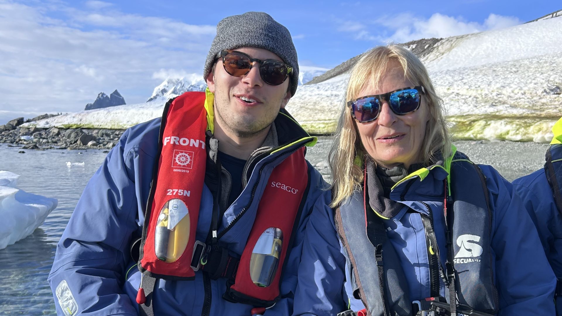 a man and a woman on Zodiac in Antarctica