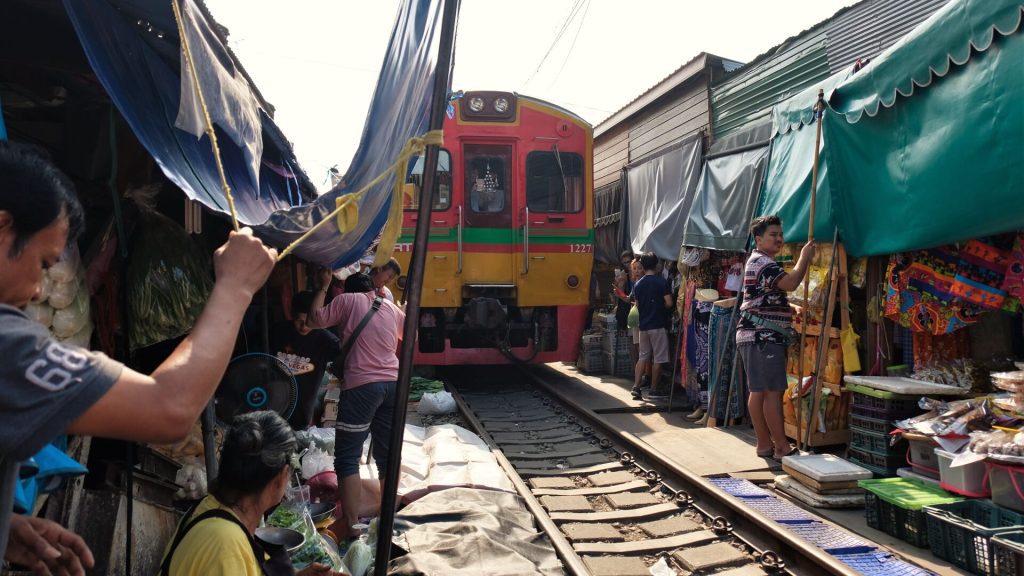 A train going through a local market in Bangkok, Thailand