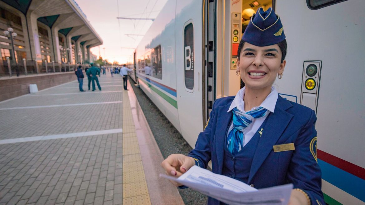 A smiley ticket inspector standing on a train station platform